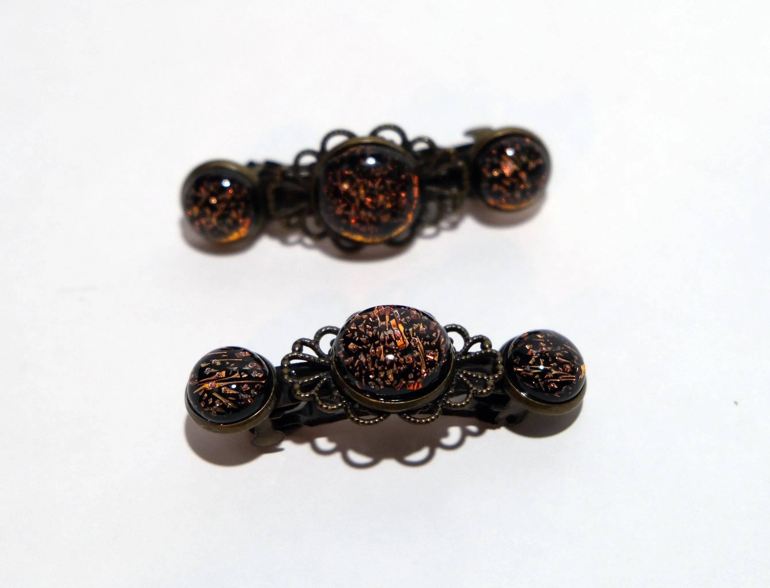 Barrette pair, bronze flowers with dark orange dichroic fused glass cabochons, french clip, 2 1/4 inches